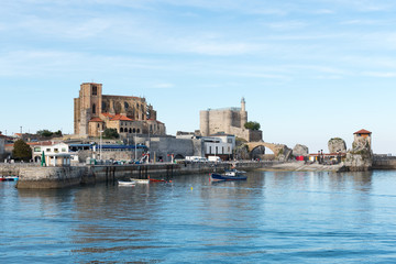Obraz premium Port of Castro Urdiales. In the background the church of Santa Maria de la Asuncion, the lighthouse of the Castle of Santa Ana and the medieval bridge