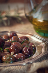Plate of black olives with olive oil 