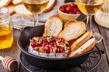 Homemade baked brie with honey, cranberry and walnut.