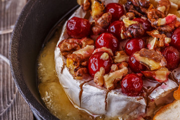 Homemade baked brie with honey, cranberry and walnut.