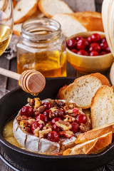Homemade baked brie with honey, cranberry and walnut. © tbralnina