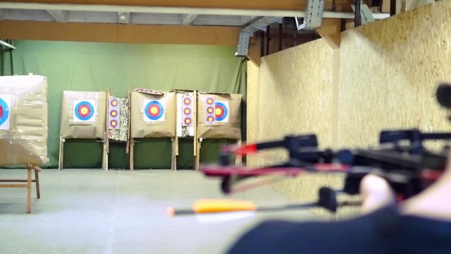 Handsome man with a bow and arrowss shoots with a crossbow in the dash in slowmotion. 1920x1080
