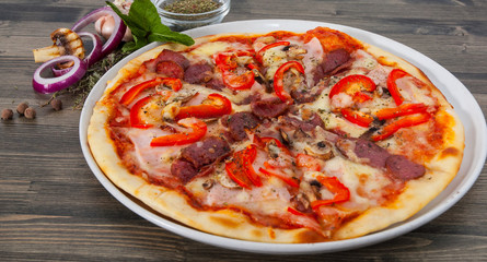Fototapeta na wymiar Appetizing pizza with mushrooms, salami, vegetables