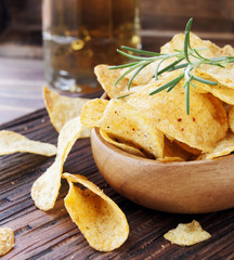 Chips in a wooden bowl and beer