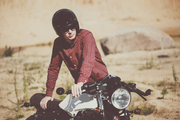 Biker with helmet start a vintage custom motorcycle. Outdoor lifestyle toned portrait - 106371188