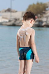 little boy in blue sea and the sun painted on the back