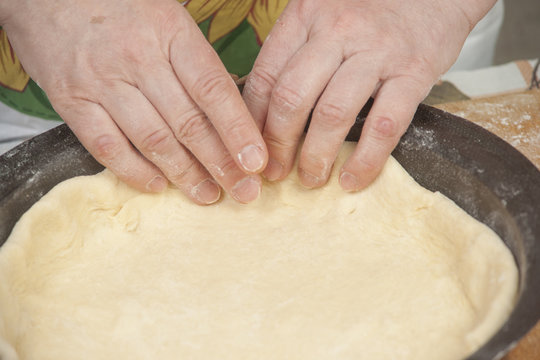 Raw dough in black metal baking form