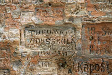 SIGULDA, LATVIA - MARCH 17, 2012: Old  inscriptions in the Gautmanis Cave located on the Gauja River in the National Park of Sigulda, Latvia