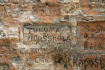 SIGULDA, LATVIA - MARCH 17, 2012: Old  inscriptions in the Gautmanis Cave located on the Gauja River in the National Park of Sigulda, Latvia