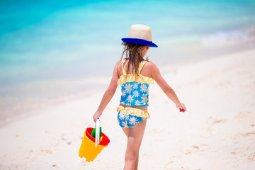 Adorable little girl during beach vacation with toys