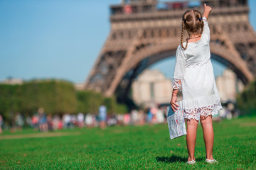 Adorable little girl with map of Paris background the Eiffel tower