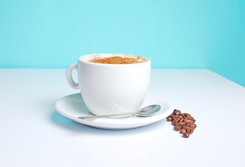 cup of coffee on the table with beans .on a blue background