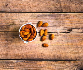 Roasted grains of peanuts in a wooden bucket isolated on white background, view from above