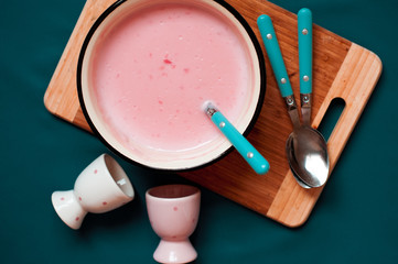 Homemade strawberry pudding on wooden board with spoons and cups. Top view. 