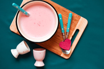 Homemade strawberry pudding on wooden board with spoons and cups. Top view. 