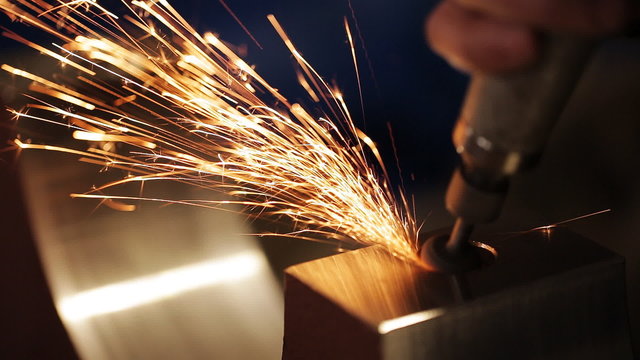finishing metal working on lathe grinder machine with flying sparks
