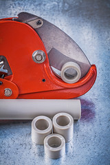 Sharp pipe cutter water tubes on scratched metallic background c