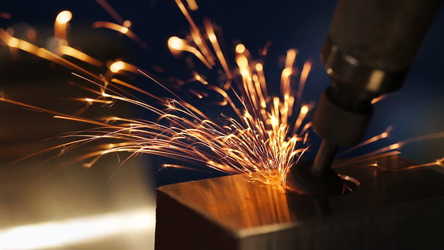 finishing metal working on lathe grinder machine with flying sparks