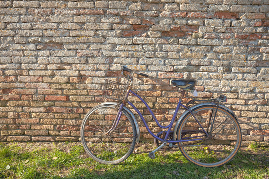 old bicycle parked long an external wall in Burano island, Venic