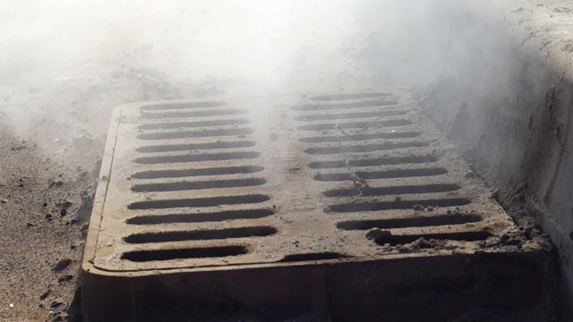 Fuming storm grate in the street