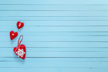Background with three red hearts on painted wooden planks. Place