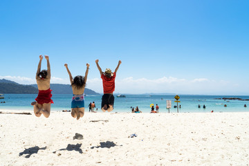 Friends jumping on the Sapi island beach
