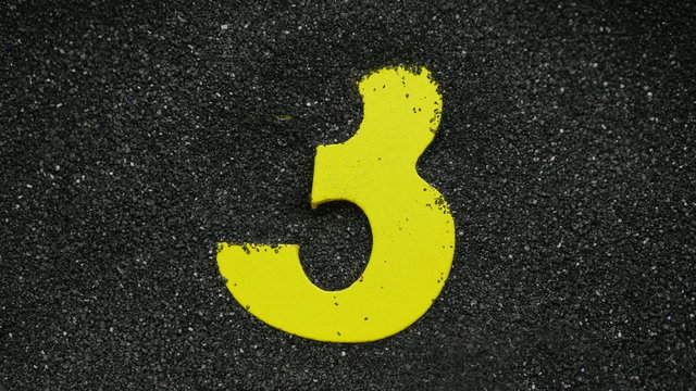 Three. Wooden number find in sand. For creation countdown.