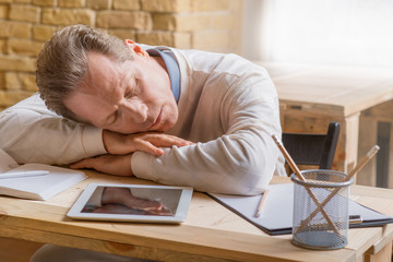 Obraz premium Sleeping man sitting at the table 