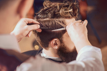 Professional barber styling hair of his client - Powered by Adobe