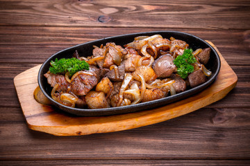 Frying pan with roasted meat and onion