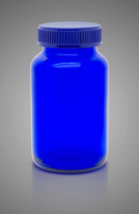 Blank blue glass bottle of supplement product isolated on gray b