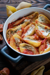 Baking dish with conchiglioni with cottage cheese stuffing