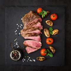 Wall murals Steakhouse Juicy steak medium rare beef with spices and grilled vegetables. Top view