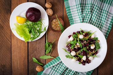 Salad of baked beets, arugula, cheese and nuts. Top view