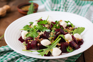 Salad of baked beets, arugula, cheese and nuts