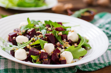 Salad of baked beets, arugula, cheese and nuts