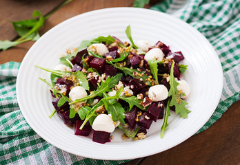 Salad of baked beets, arugula, cheese and nuts