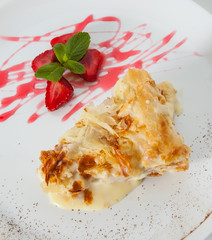 slice of decorated with strawberry napoleon cake, served on white plate