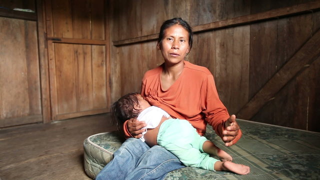 Mother and child living in impoverished conditions in the Ecuadorian Amazonia,showcasing their unique cultural heritage through heartfelt Quechua language songs.