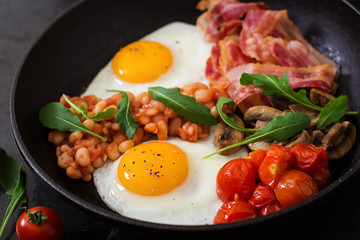 English breakfast - fried egg, beans, tomatoes, mushrooms, bacon and toast