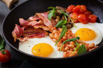 English breakfast - fried egg, beans, tomatoes, mushrooms, bacon and toast
