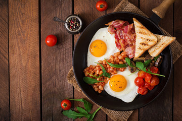 Petit-déjeuner anglais - œuf au plat, haricots, tomates, champignons, bacon et pain grillé. Vue de dessus