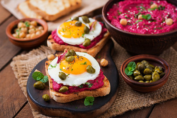 Fototapeta na wymiar Diet sandwiches with beet root hummus, capers and egg