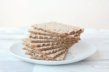 Dry bread on the plate on the wooden background