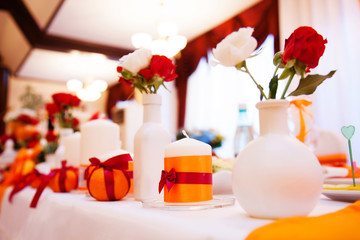 Wedding candles on restaurant table. Wedding in orange colors