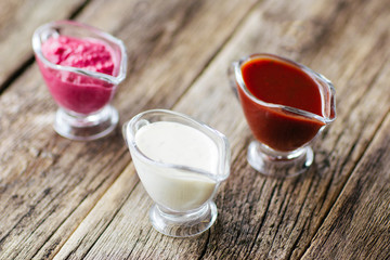 several sauces  of European cuisine. Several sauces : mayonnaise, ketchup, horseradish.  Top view on european cuisine  food on wooden background.