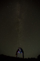 Couple is standing in mountains against night sky with milky way