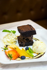 Set of dessert with ice cream, brownies, whip cream and fruits topping