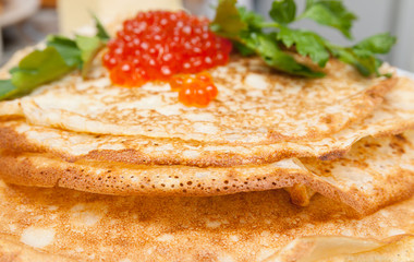 Russian pancakes with red caviar on a plate
