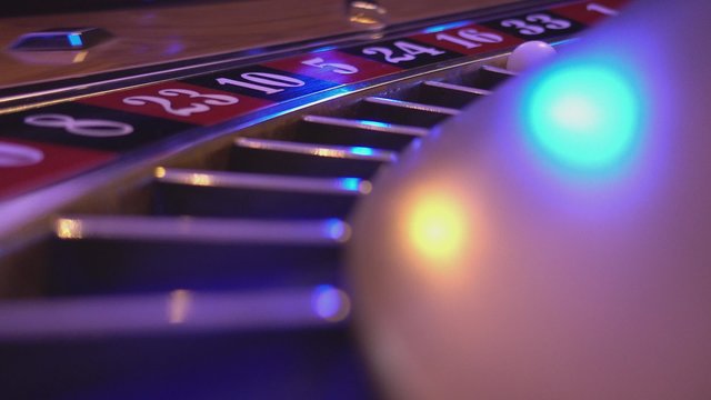 Macro view on a Roulette Wheel in a casino - ball falls in field 16 red